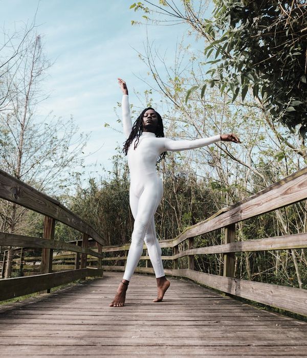 Woman performing a calm, flowing movement in a serene environment.